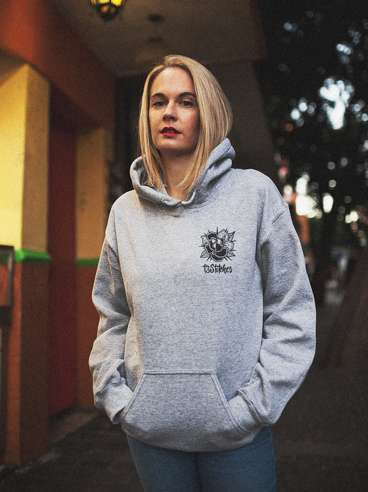 13stitches blonde girl wearing a grey unisex hoodie with tattoo design of a panther and lotus flowers